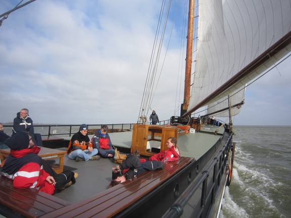 Guests on the foredeck of the Broedertrouw under sail