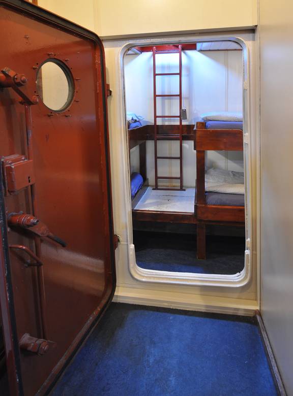 View through a ship doorway into a four-berth cabin of the Chateauroux