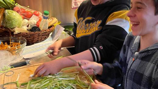 School pupils chopping vegetables for a meal aboard a ship