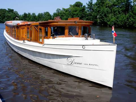 Saloon boat Dame van Amstel with a wooden cabin on the water