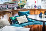 Seating area with turquoise cushions on the aft deck of the Dame van Amstel