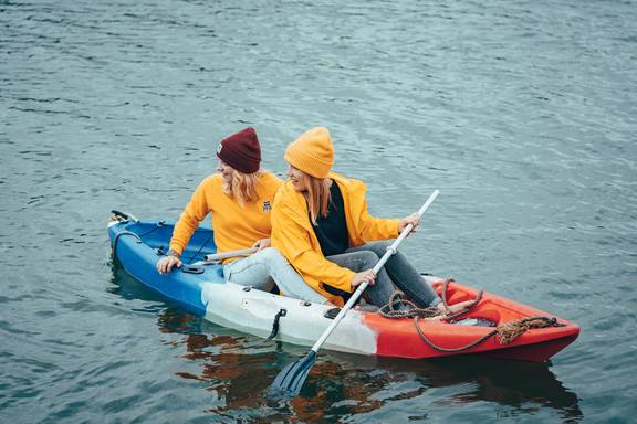 Two guests paddling canoes on the water
