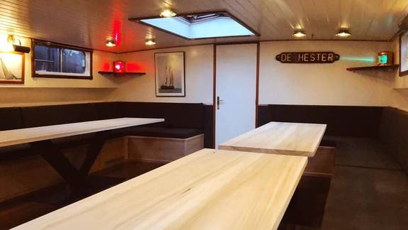 Saloon of De Hester with light wooden tables and benches