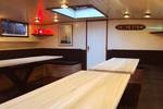 Saloon of De Hester with light wooden tables and benches