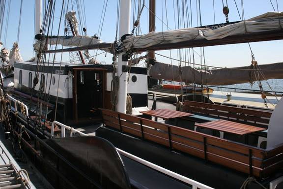 Wooden benches and tables in the deck seating area of the Vrijheid