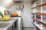 Galley of De Hester with a gas cooker and open storage shelves