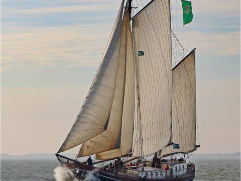 Eenhoorn under sail with spray at the bow