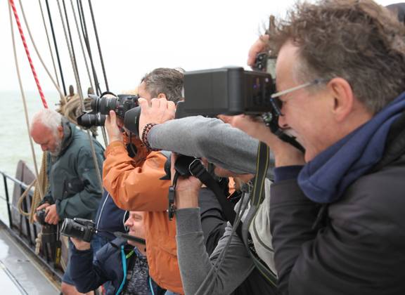 Participant taking photographs during a photography workshop on board