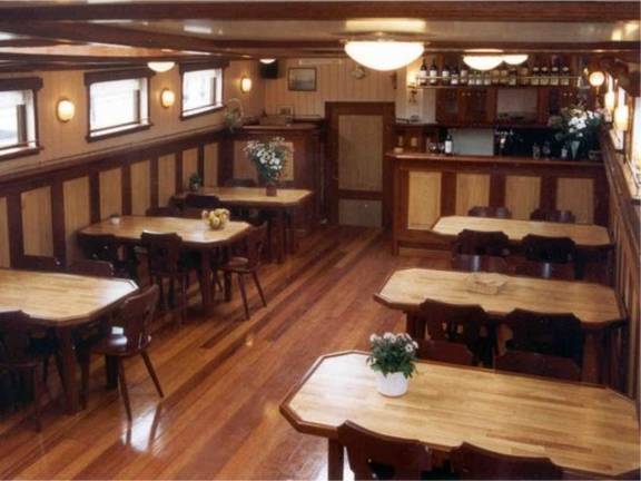 Wooden dining tables and chairs in the saloon of the Frisius van Adel