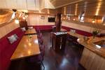 Saloon of the Grietje with wooden dining tables and red benches