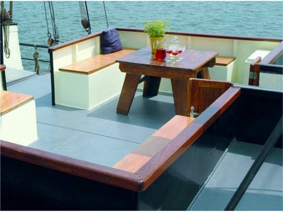 Deck seating area of the Johanna Engelina with benches and a wooden table