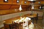 Seating area with a wooden dining table in the saloon of the Korevaer
