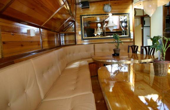 Seating area with a wooden dining table in the saloon of the Korevaer