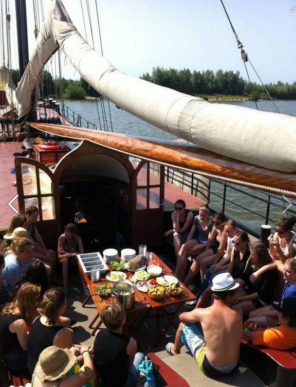 Guests sharing a meal in the deck seating area of the Korevaer
