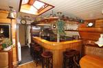 Wooden bar with stools beside the galley of the Korevaer