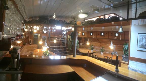 Saloon of the Korevaer with a wooden bar and seating area
