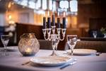 Table set with lit candles in the dining room of the Leafde fan Fryslân