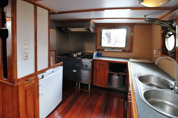 Galley of the Mars with a double sink and wooden cupboards