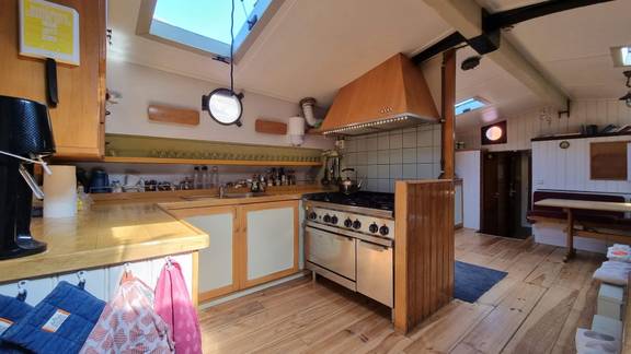 Open galley with a cooker and wooden cabinets on the Medusa