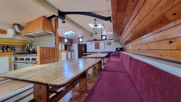Saloon of the Medusa with long wooden tables and red benches