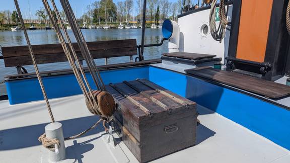 Deck seating area with blue benches on the Meridiaan