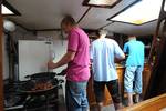 Guests cooking together in the galley of the Nieuwe Zorg