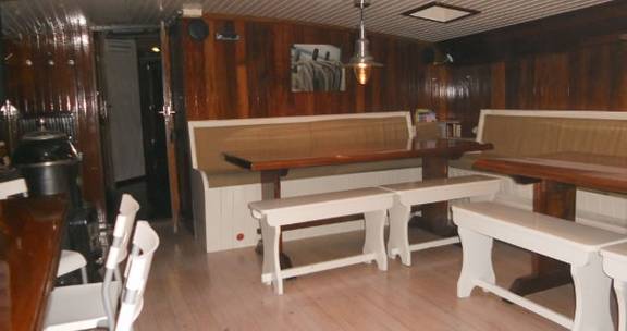 Saloon of the Nieuwe Zorg with wooden tables and white benches