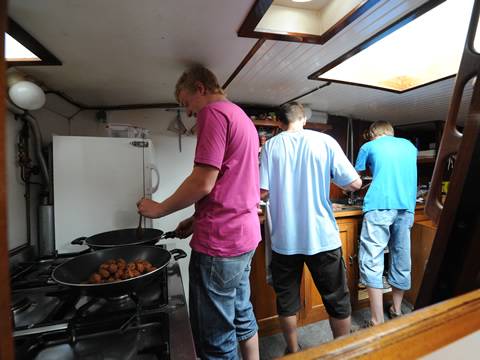 Guests cooking together in the galley of the Nieuwe Zorg