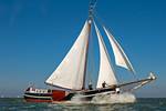 Tjalk Orion under white sails on the water