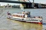 Saloon boat Oude Maze cruising beside a bridge in Rotterdam