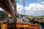 View over the deck of the Pelikaan beside a green shore