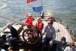 Guests at the wheel on the aft deck of the Pelikaan