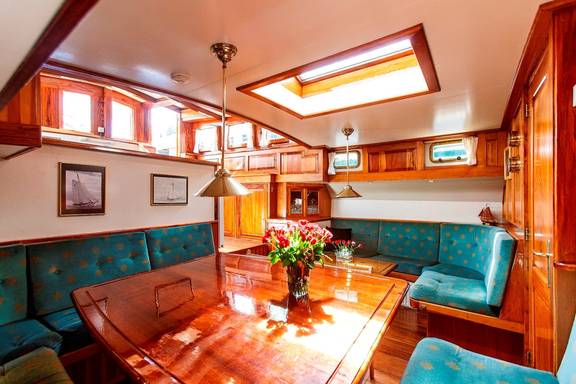 Saloon of the Pelikaan with a wooden dining table and green benches