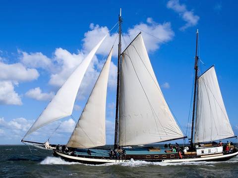 Two-masted clipper Poseidon under white sails on the water