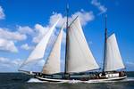 Two-masted clipper Poseidon under white sails on the water