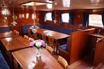 Saloon of the Pouwel Jonas with wooden dining tables and red benches