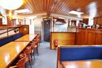 Saloon of the Rival with wooden tables and blue benches