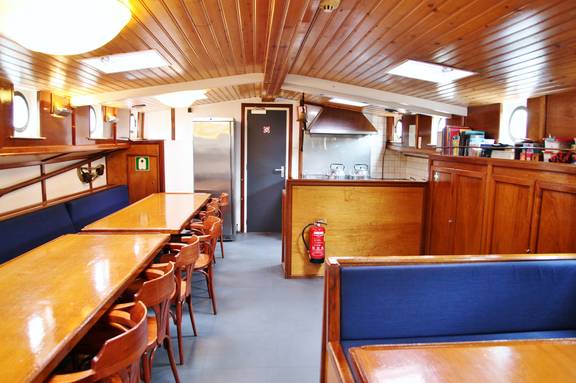 Saloon of the Rival with wooden tables and blue benches