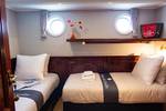 Twin-berth cabin with portholes on the Simmer fan Fryslân