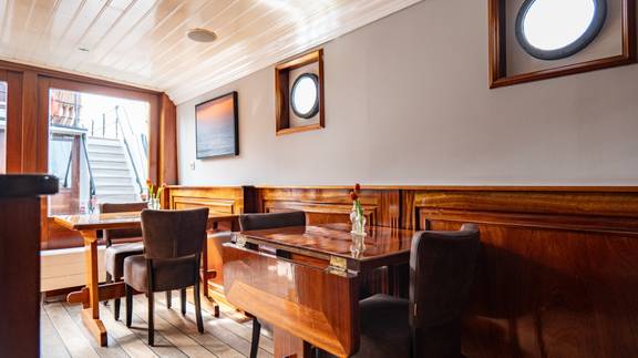 Seating area with a wooden table and chairs on the Simmer fan Fryslân