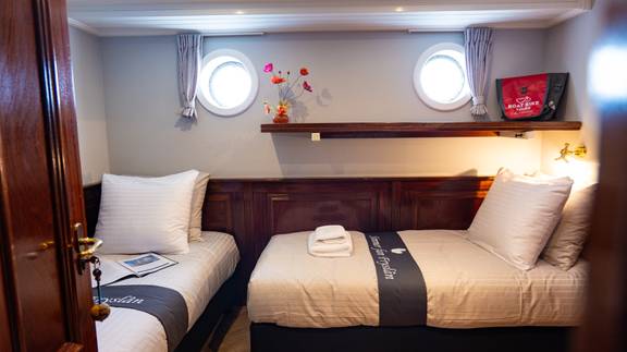 Twin-berth cabin with portholes on the Simmer fan Fryslân