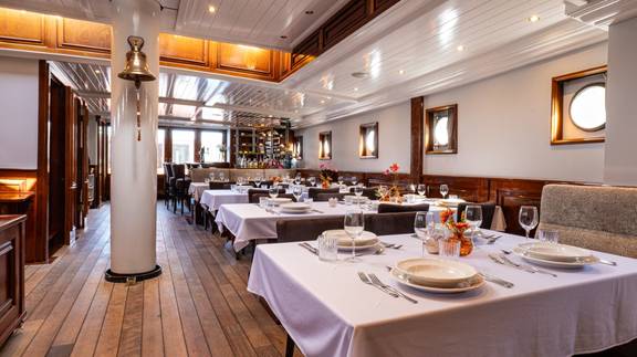 Dining tables set beside the windows of the Simmer fan Fryslân