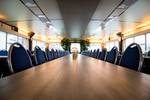 Long meeting table with blue chairs in the saloon of the Smaragd 2