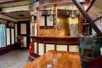 Wooden dining table and bar in the saloon of the Spartivento