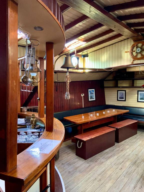 Saloon of the Spartivento with a bar and dining table