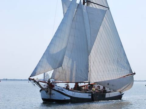 Tjalk Spes Mea under white sails, viewed diagonally from the bow