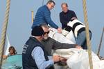 Guests folding a sail together aboard the Spes Mea