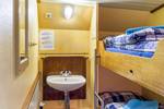 Twin-berth cabin with a bunk bed and washbasin on the Spes Mea