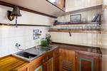 Galley with wooden cabinets and a sink on the Spes Mea