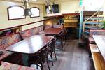 Saloon of the Sybaris with wooden dining tables and benches